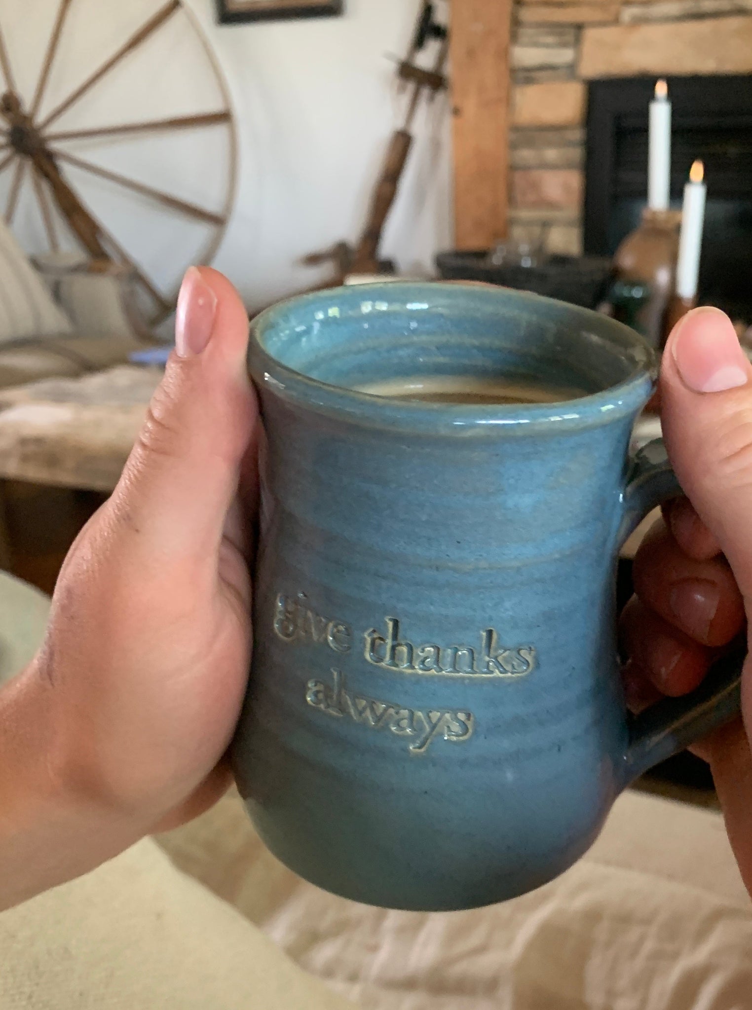Three Gratitude Mugs with unique designs and glaze colors: "eucharisteo" with cloud blue glaze on white clay, "give thanks always" with darker blue glaze and ochre undertones, and "be still" with variegated gray glaze on red clay. Elegant shape, slight ripples, curved handles. Perfect for reflection and gifting.